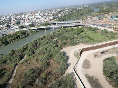 A U.S. Customs and Border Protection helicopter patrol flies over a border fence by a bridge between the United States and Mexico on Oct. 18, 2016 in Hidalgo, Texas.